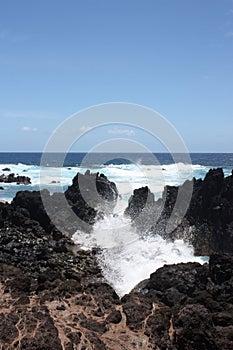 Waves crashing onto volcanic rock on the shore of Laupahoehoe Point on the Hamakua Coast, Hawaii