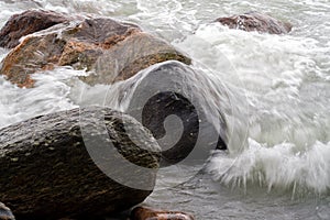 Waves Crashing over Granite Boulders at shoreline