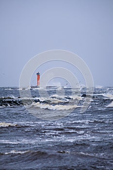 Waves crashing over a lighthouse, lighthouse in the sea in stormy day. Selective focus