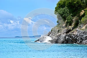 Waves crashing over rock formation cliffs of greece