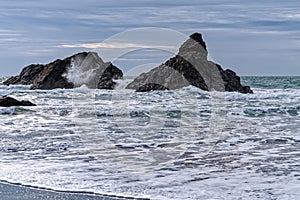 Waves crashing over the sea stacks on the Pacific coast at Harris Beach State Park, Oregon, USA