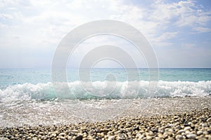 Waves crashing on rocks. blue waves, sand beach and blue sky. Gr