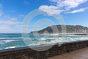 Waves crashing on rocks of San Sebastian coast, Spain. Scenic bay of Biscay in San Sebastian, Donostia. Surf concept.