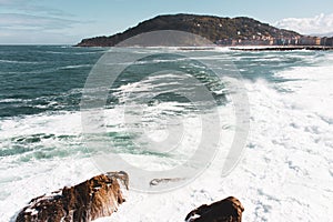 Waves crashing on rocks of San Sebastian coast, Spain. Scenic bay of Biscay in San Sebastian, Donostia. Surf concept.