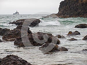 Waves Crashing on Rocks with Tillamook Lighthouse photo