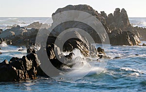 Waves crashing on rocky coastline near Monterey, California, USA