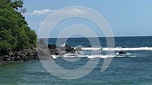 Waves crashing on sandy beach, sea surf on tropical sandy beach, fishermen catch fish on a fishing rod