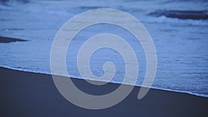 Waves crashing on Santa Severa sandy beach, at twi
