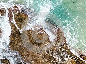 Waves crashing on seashore rocks,Top view sea surface waves background