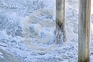 Waves crashing on to pier pilings