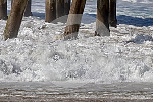 Waves crashing on to pier pilings