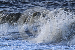 Waves with foam heads hit the coast of Goeree Overflakkee
