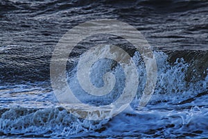 Waves with foam heads hit the coast of Goeree Overflakkee