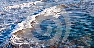 Waves forming before crashing upon a beach