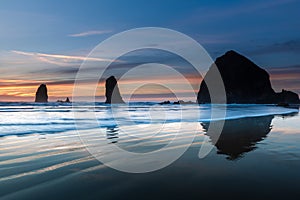 Waves in front of Cannon beach haystack at blue hour