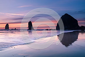 Waves in front of Cannon beach haystack at sunset