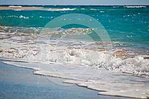 Waves gently crash onto the sandy beach