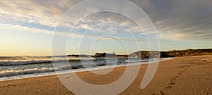 The waves and golden sand of a deserted beach