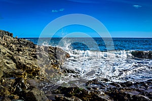 Waves gran ganaria with rocks and a fishing man