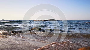 Waves at greek coastline crashing on rocks at beach