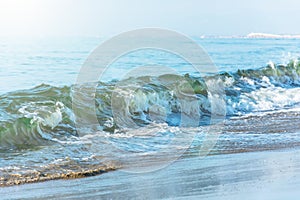 Waves with a green tint on the beach