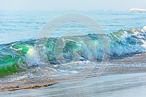 Waves with a green tint on the beach