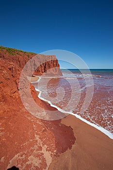 Waves at high tides breaking against the red pindan cliffs at James Price Point, Western Australia