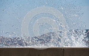 Waves hit the concrete wall and splashing sea water