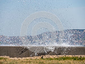 Waves hit the concrete wall and splashing sea water