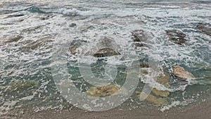 The waves hit the coral rocks on the beach