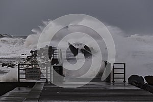 waves hitting against the pier during the storm in Nr. Vorupoer on the North Sea coast