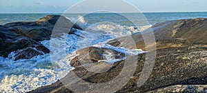 Waves hitting rocks and spraying the coastline