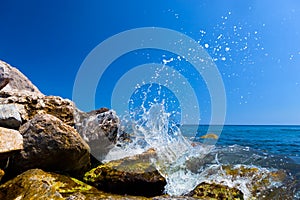 Waves hitting rocks on a tropical beach. Greece, Santorini.