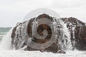 Waves hitting a sea rock with great force