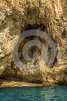 Waves lap against the base of the White Grotto on the Island of Capri, Italy