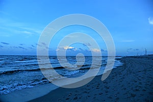 Waves lap the tropical beachfront as storms develop over the horizon