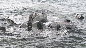 Waves lapping gently against large boulders