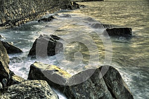 Waves over rocks at sunset on the bay of biscay beach in spain