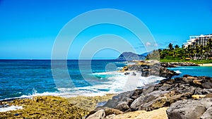 Waves of the Pacific Ocean crashing on the rocks on the shoreline of Ko Olina on the island of Oahu