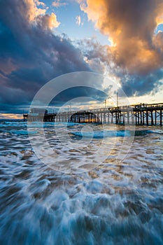 Waves in the Pacific Ocean and the Newport Pier at sunset