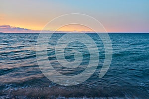 Waves on a pebble beach on a sunset. Natural background.