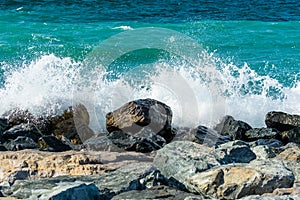 Waves of Persian Gulf splashing the stones of breakwater  at the crescent road in the Palm Jumeirah island in Dubai of the United