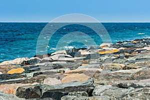 Waves of Persian Gulf splashing the stones of breakwater  at the crescent road in the Palm Jumeirah island in Dubai of the United