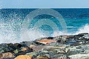 Waves of Persian Gulf splashing the stones of breakwater  at the crescent road in the Palm Jumeirah island in Dubai of the United