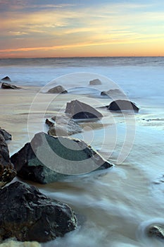 Waves recede around a stoney shoreline