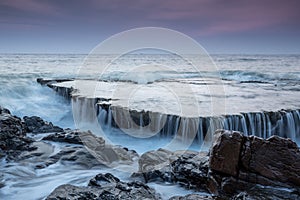 Waves, rock in sunrise