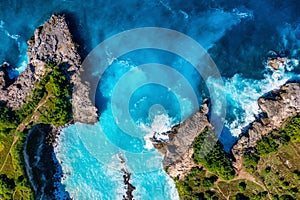 Waves and rocks as a background from top view. Blue water background from top view. Summer seascape from air.