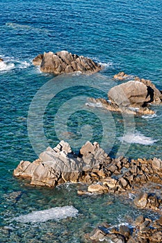 Waves on rocky beach, sea shore with waves crushing over the big rocks