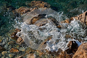 Waves on rocky beach, sea shore with waves crushing over the big rocks