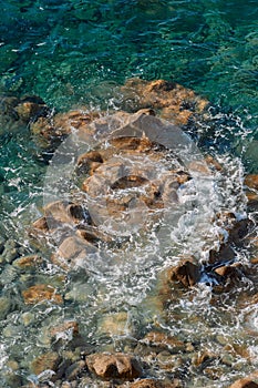 Waves on rocky beach, sea shore with waves crushing over the big rocks